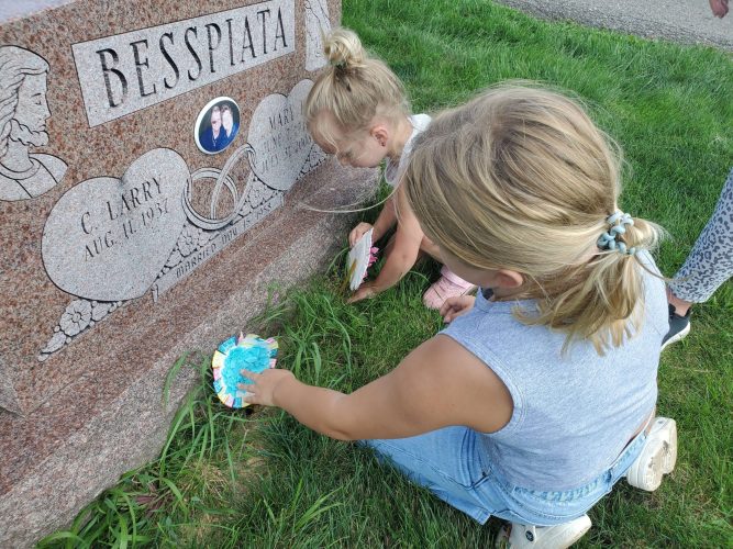 Placing paper flowers on the grave